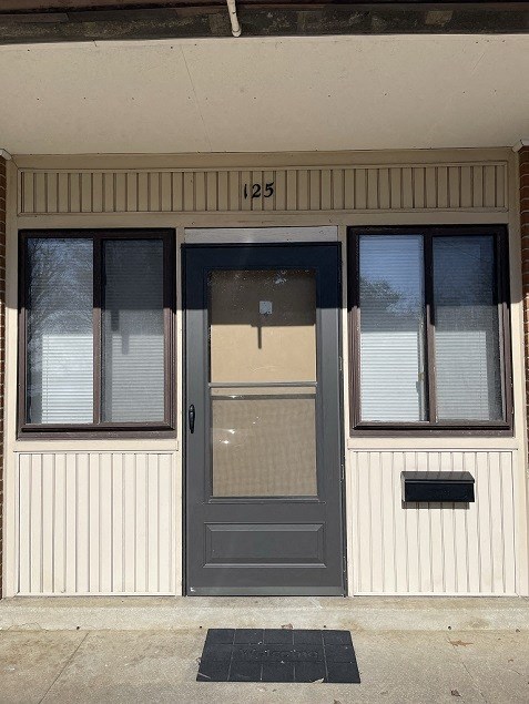 the front of a building with a gray door