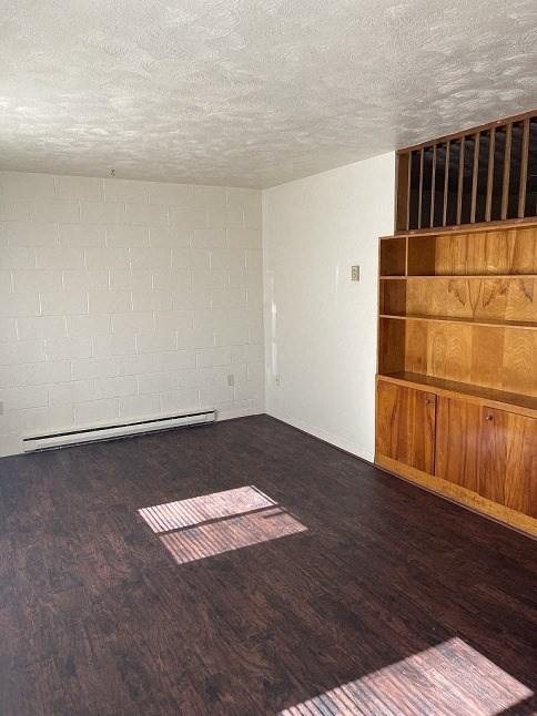an empty living room with wooden floors and white walls