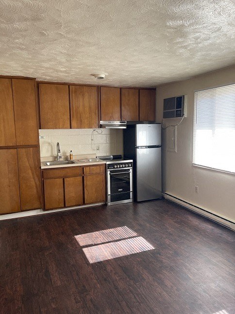an empty kitchen with a stove and a refrigerator