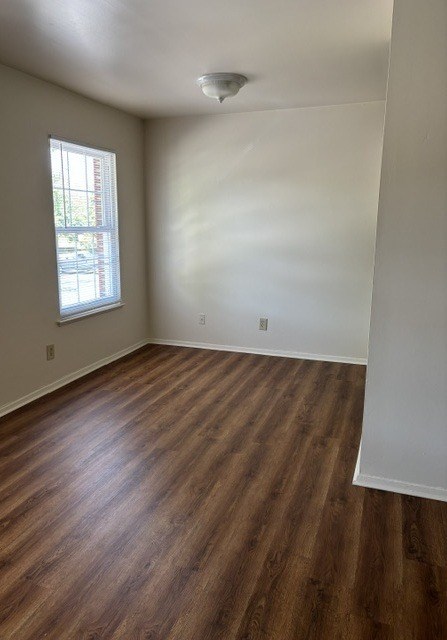 A room with wooden flooring and a window.