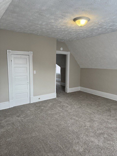 A room with a white door and carpeted floor.