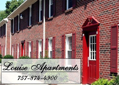 A red brick building with a sign that says Louise Apartments.