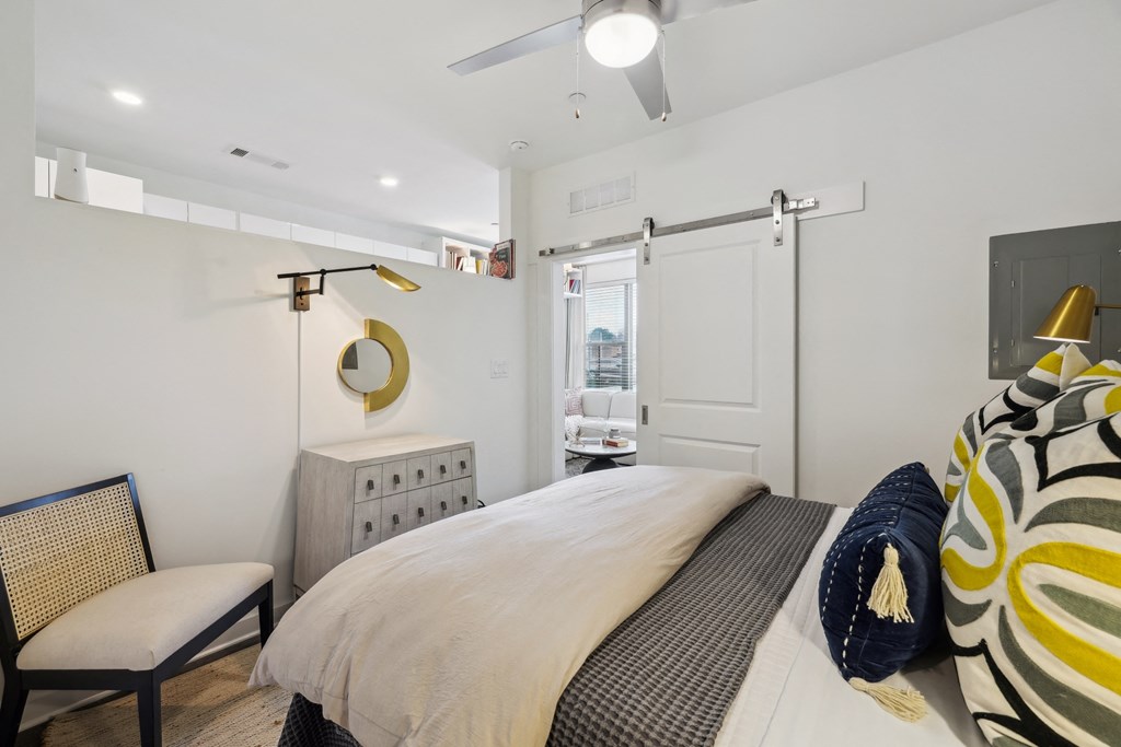 a bedroom with a bed and a dresser and a door to a bathroom