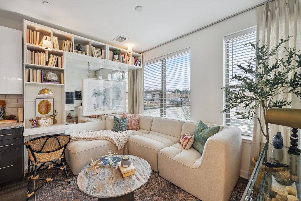 a living room with a couch and a table     and a window