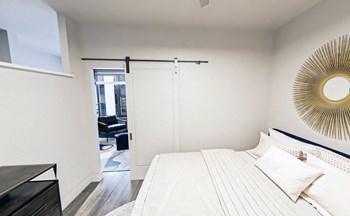 Large bedroom with partial wall and king bed Large bedroom with partial wall and king bed at Link Apartments® Mint Street, Charlotte, NC - Photo Gallery 5