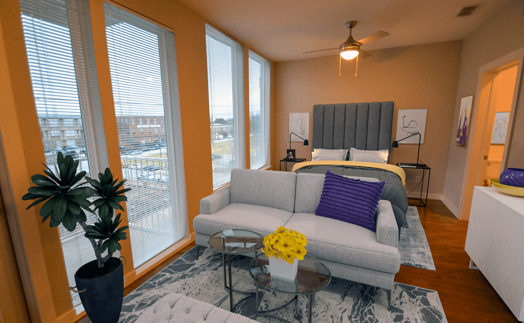a living room with a couch and a bed in a room with large windows a living room with a couch and a bed in a room with large windows at Link Apartments® Canvas, Atlanta, GA, 30312