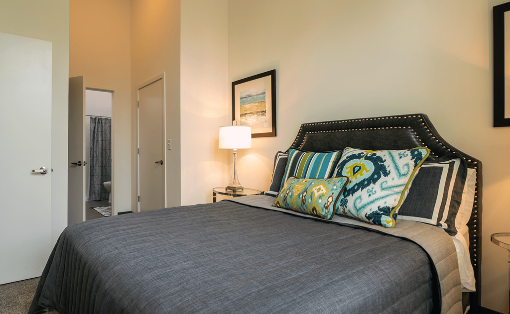 a bedroom with a bed and a door to a bathroom a bedroom with a bed and a door to a bathroom at Link Apartments® Canvas, Atlanta, GA, 30312
