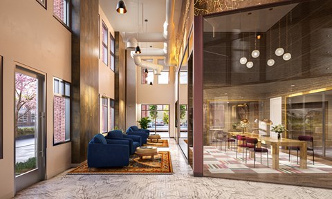 a lobby with blue couches and a table with chairs and a large glass door