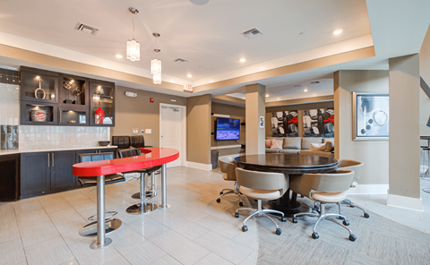 a clubhouse with a red bar and a tv in the back  at Link Apartments® Brookstown, North Carolina