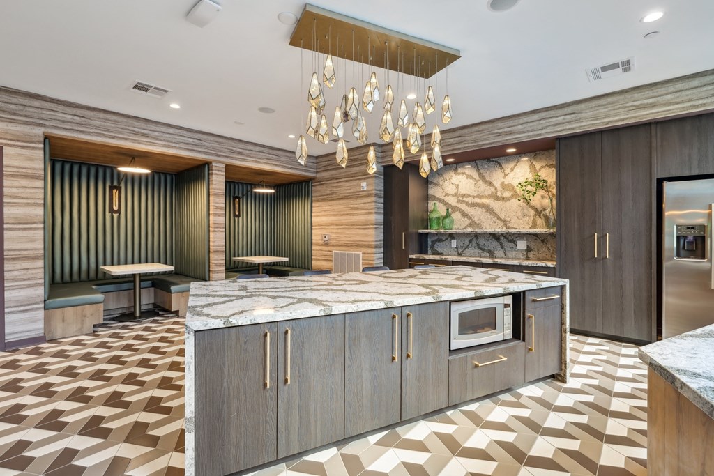 a large kitchen with marble countertops and a chandelier