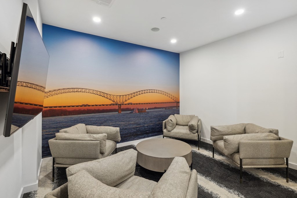 a living room with couches and a wall mural of a bridge
