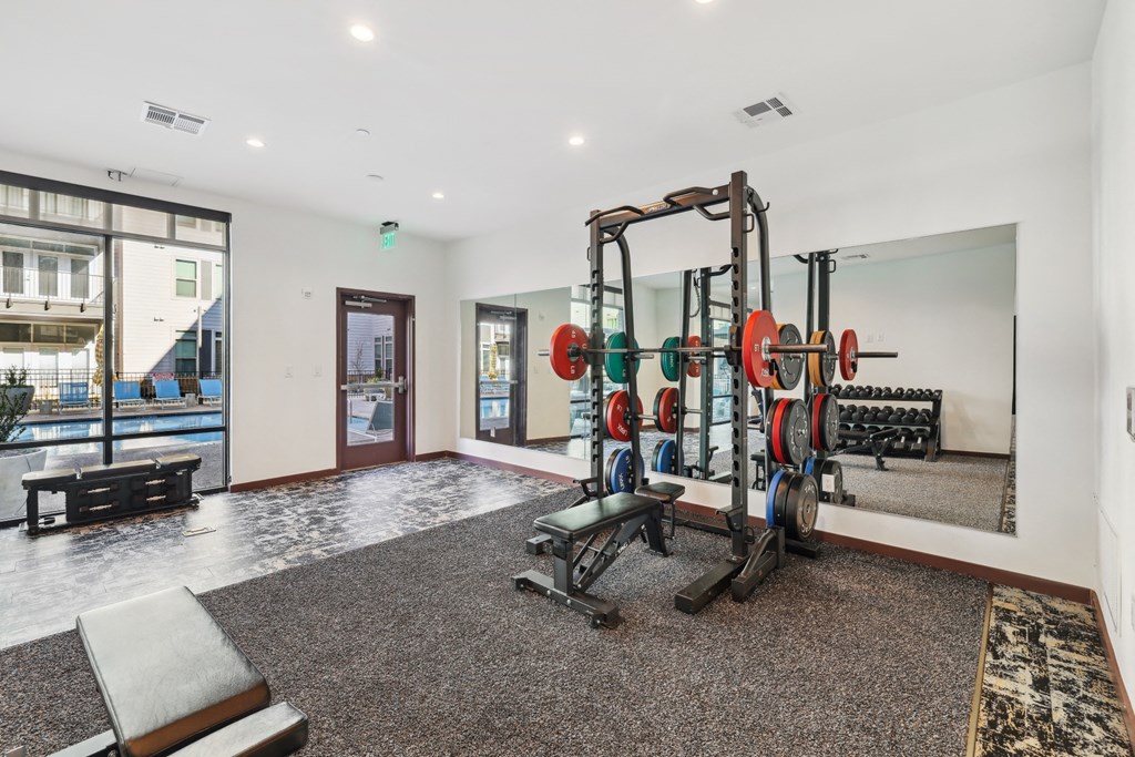a gym with weights and dumbbells in the corner of a room