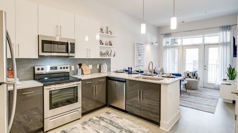 Kitchen attached to living room at Link Apartments® Grant Park, Atlanta, GA