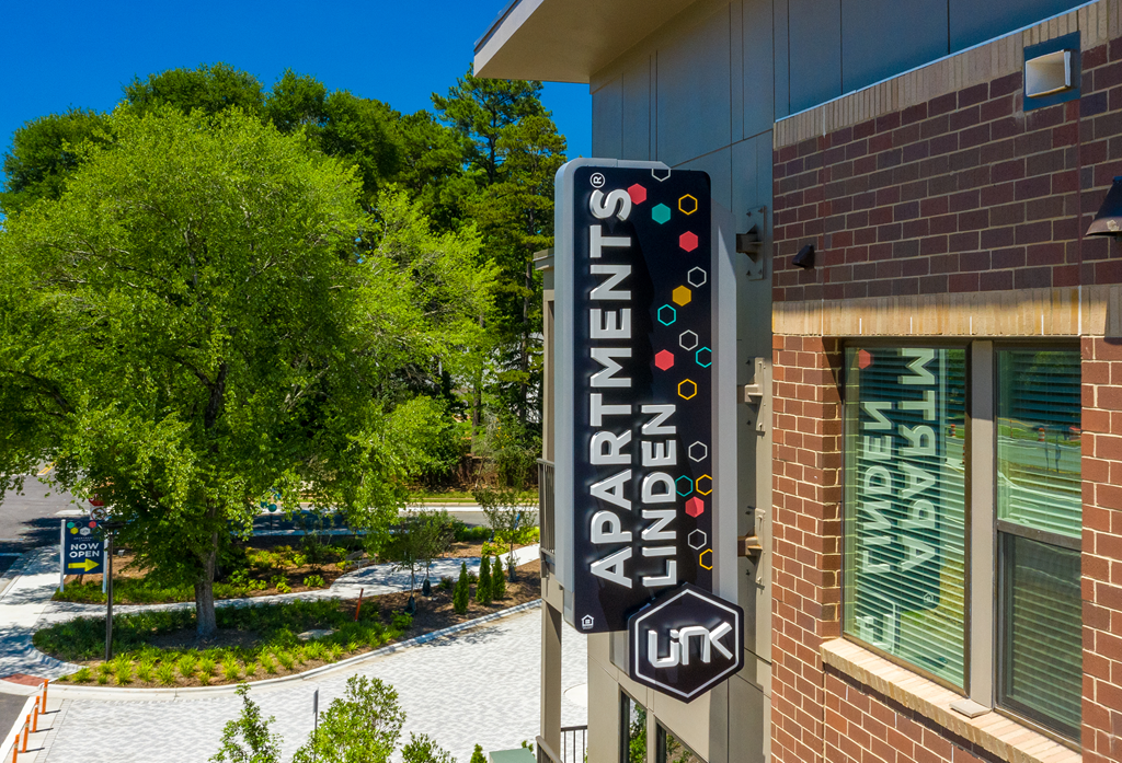 Building sign and trees at Link Apartments® Linden in Chapel Hill, NC