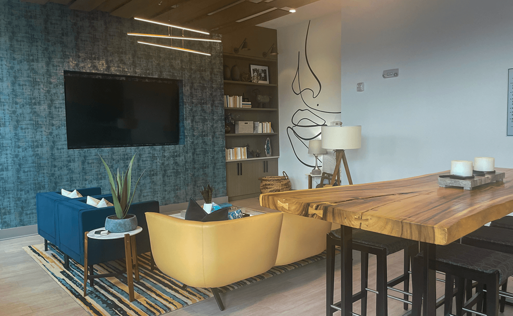 a living room with a tv and a wooden table a living room with a tv and a wooden table at Link Apartments® Canvas, Atlanta, 30312