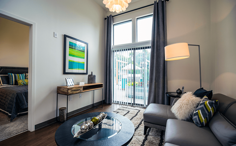 a living room with a large window and a sliding glass door  at Link Apartments® Canvas, Atlanta, 30312