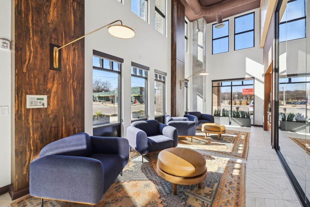 a lobby with blue chairs and tables and windows