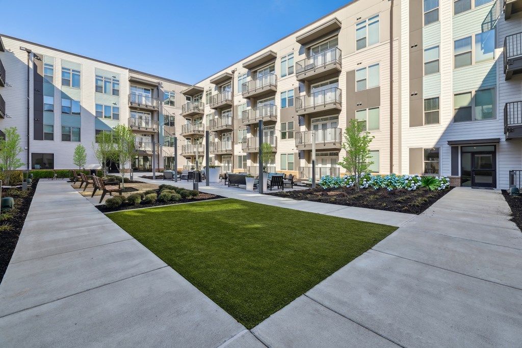 an exterior view of an apartment building with a sidewalk and grass