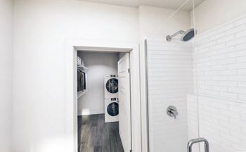 Large bathroom with shower stall and huge closet with Smart Home washer/dryer at Link Apartments Mint Street in Charlotte, NC.