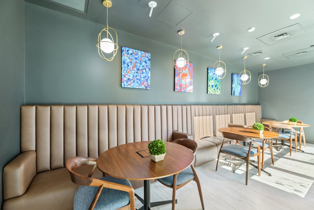 a dining room with tables and chairs and blue walls at Link Apartments® H Street, Washington