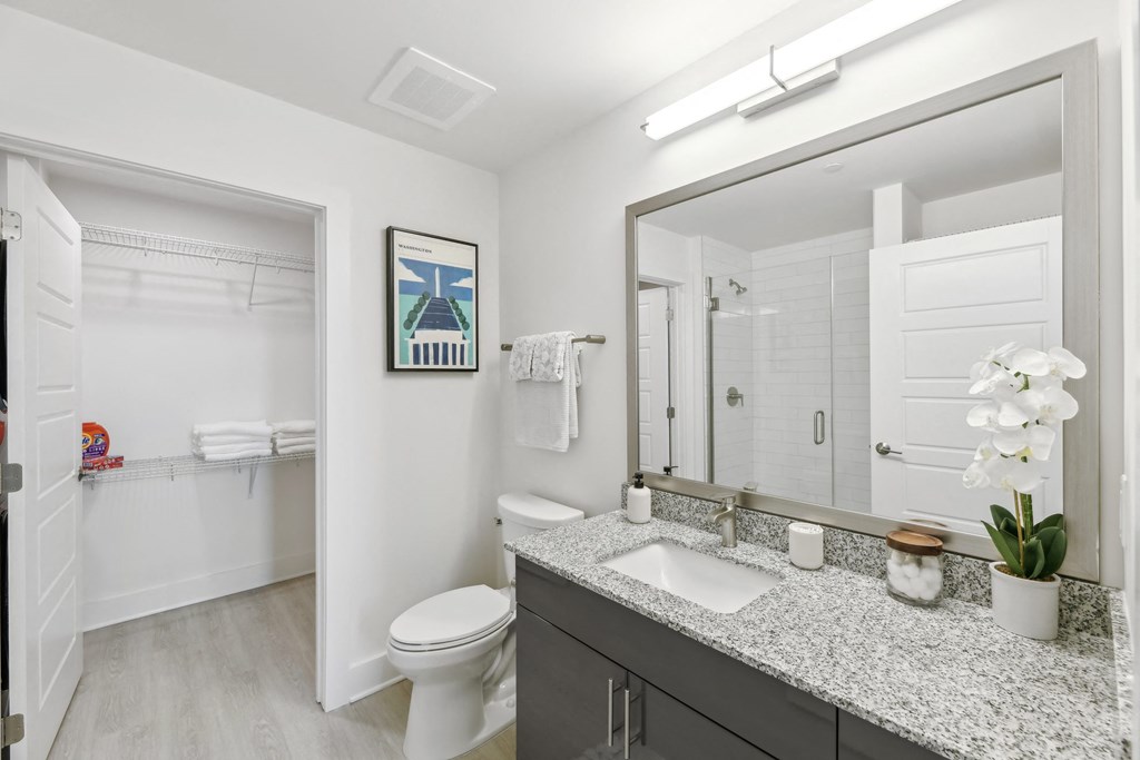 a bathroom with a large mirror and a toilet and a sink  at Link Apartments® H Street, Washington, 20002
