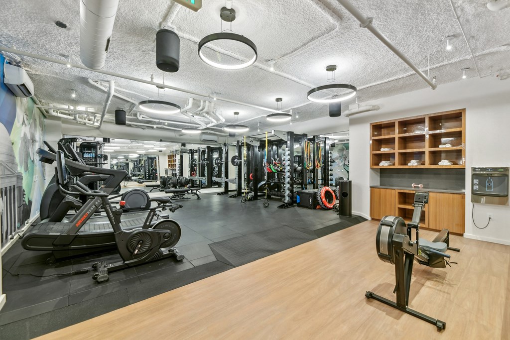 a gym with weights and other exercise equipment on a wooden floor  at Link Apartments® H Street, Washington, Washington