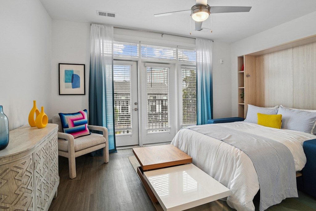 a bedroom with a bed and a sliding glass door a bedroom with a bed and a sliding glass door at Link Apartments® Mint Street, Charlotte, North Carolina