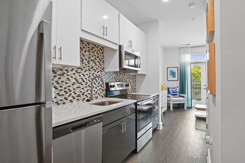 a kitchen with stainless steel appliances and white cabinets