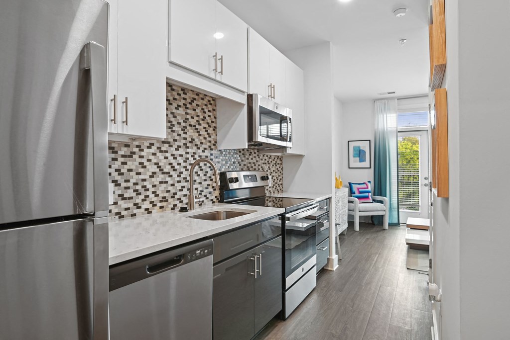 Studio kitchen with stainless steel appliances and quartz counters at Link Apartments® Mint Street in Uptown Charlotte, NC. Studio kitchen with stainless steel appliances and quartz counters at Link Apartments® Mint Street in Uptown Charlotte, NC. at Link Apartments® Mint Street, Charlotte, NC, 28203