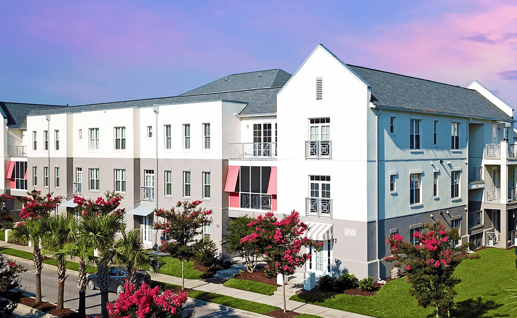 an aerial view of a row of white apartment buildings with red and blue awnings  at Link Apartments® Mixson, North Charleston, 29405