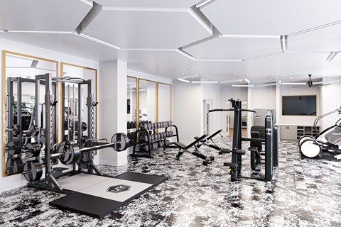 a gym with weights and a tv on the wall and a marble floor