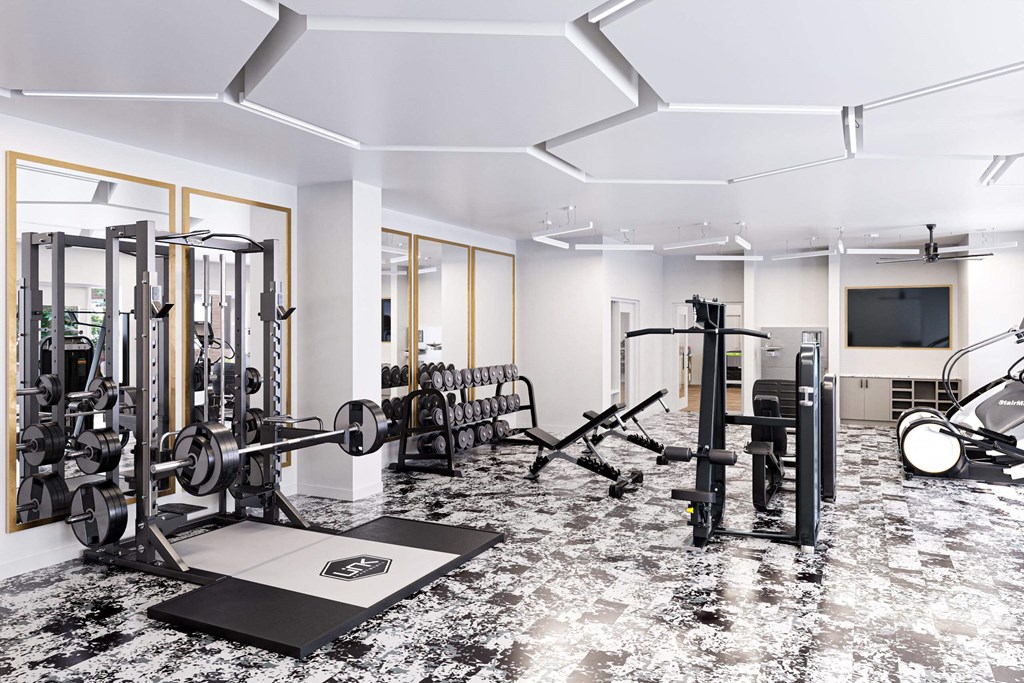 a gym with weights and a tv on the wall and a marble floor at Link Apartments® Calyx, North Carolina