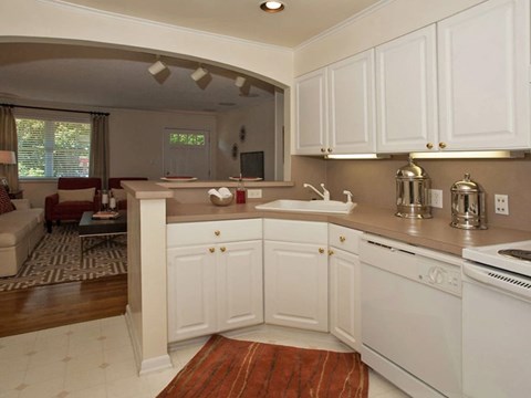 A kitchen with white cabinets and a white stove.