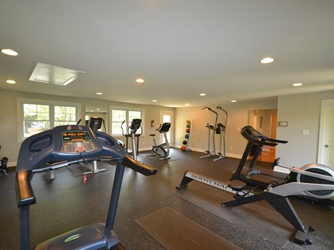 A gym with a treadmill, exercise bike, and other equipment.
