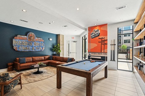 a game room with a pool table and couches