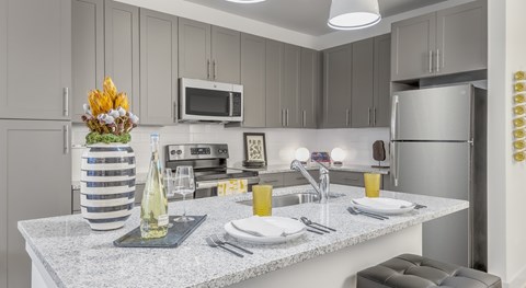 A kitchen with a countertop and a microwave above it.