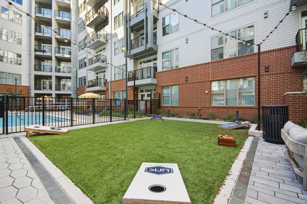 an apartment yard with a pool and an apartment building at Link Apartments® Calyx, Chapel Hill, NC 27517