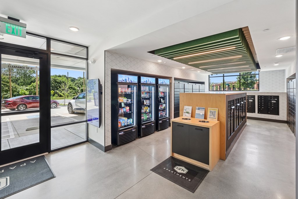 A modern office lobby with a reception desk and a view of the parking lot outside at Link Apartments® CYKEL Apartments, Charlotte, NC, 28208