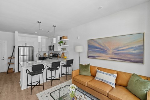 A modern living room with a brown sofa and a painting on the wall.