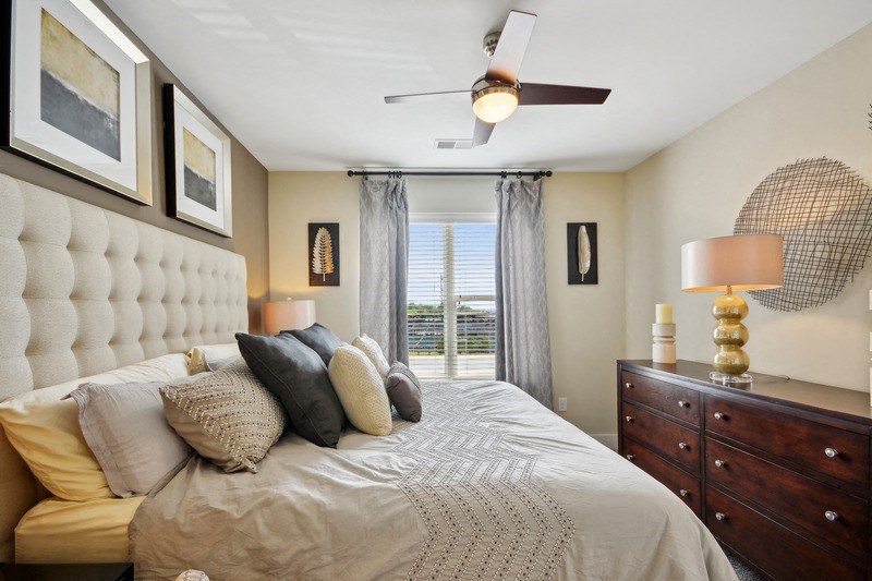 a bedroom with a large bed and a ceiling fan at Link Apartments® Brookstown, North Carolina