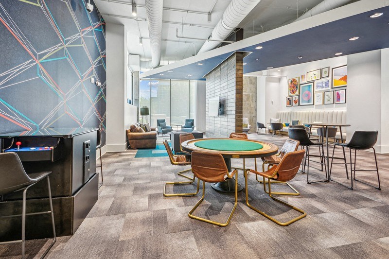 a room with a round table with chairs and a television at Link Apartments Innovation Quarter, North Carolina, 27101