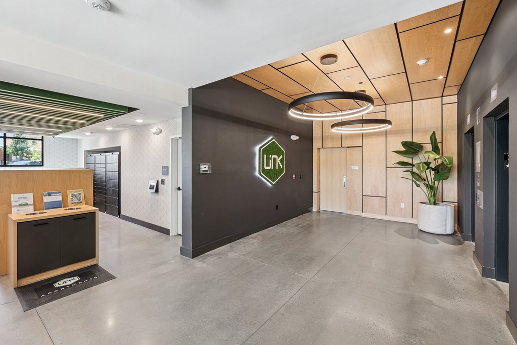 A hallway with a black door and a green logo on it at Link Apartments® CYKEL Apartments, North Carolina