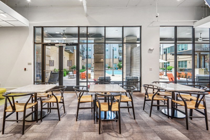 a dining area with tables and chairs and glass doors at Link Apartments Innovation Quarter, North Carolina, 27101