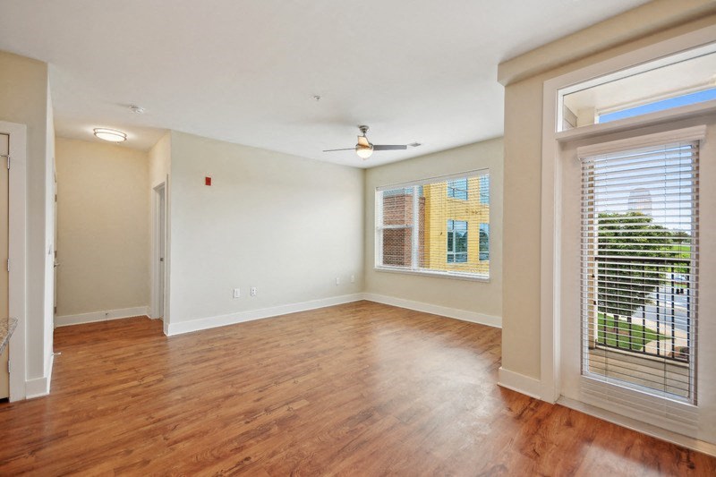 an empty living room with a large window and wood flooring at Link Apartments® Brookstown, Winston Salem, NC, 27101