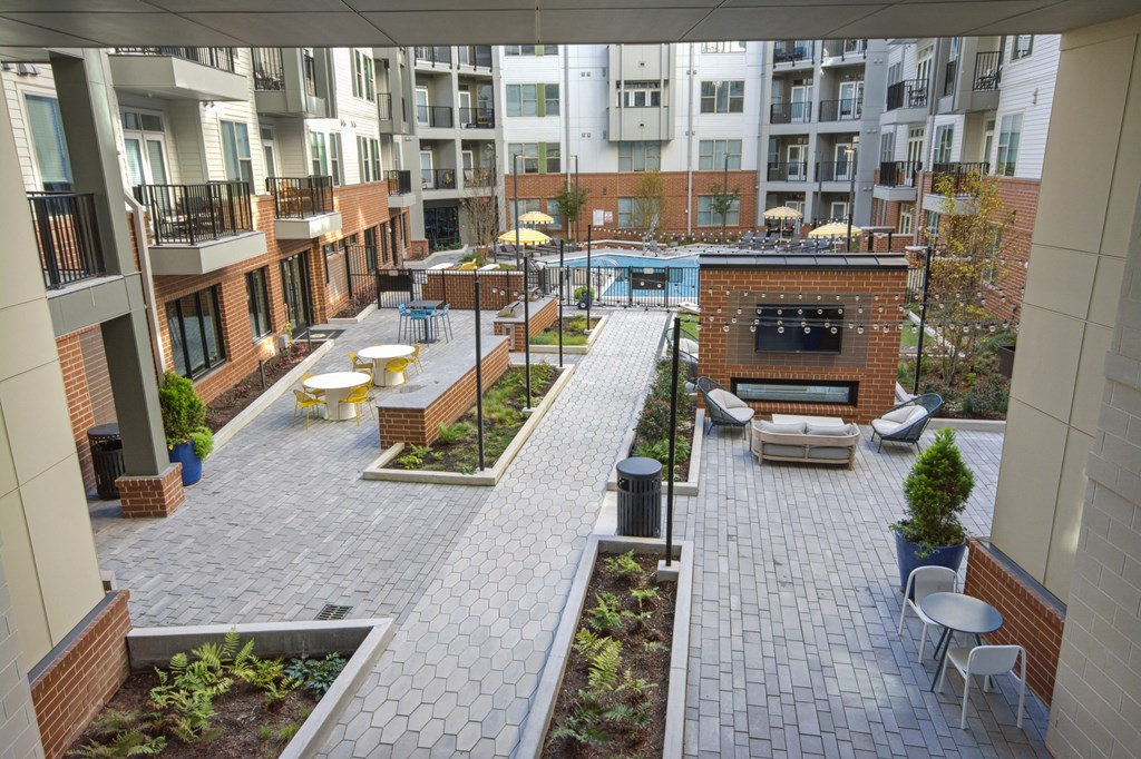 an open courtyard with benches and tables in an apartment building at Link Apartments® Calyx, Chapel Hill, NC 27517