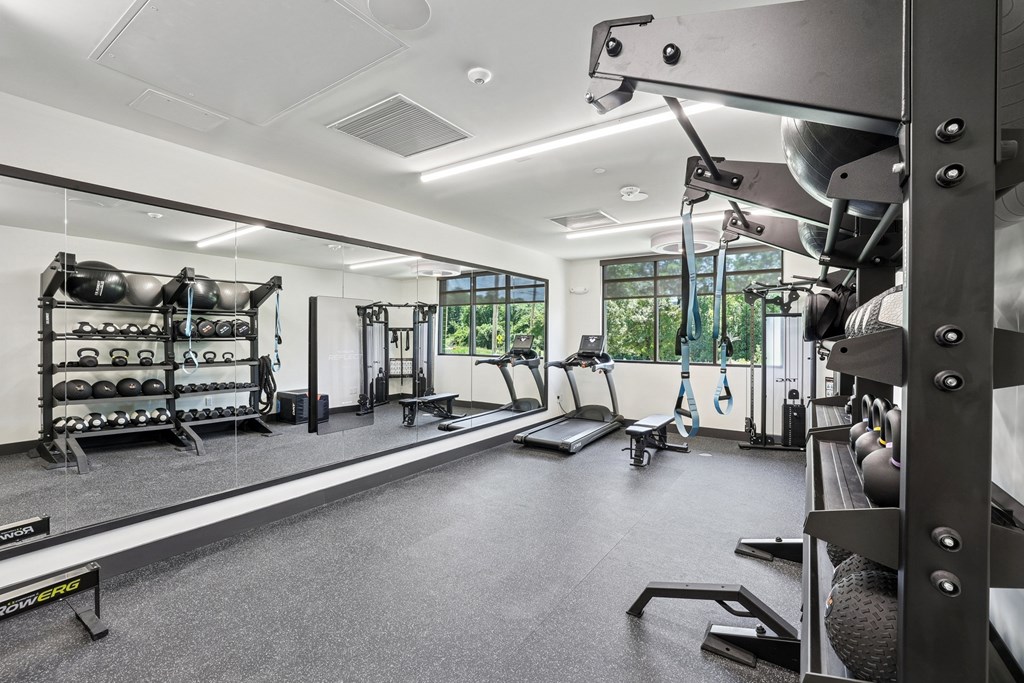 A well-equipped gym with various exercise machines and weights at Link Apartments® CYKEL Apartments, North Carolina, 28208