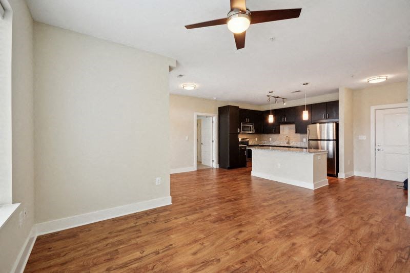 an empty living room and kitchen with a ceiling fan at Link Apartments® Brookstown, Winston Salem, NC