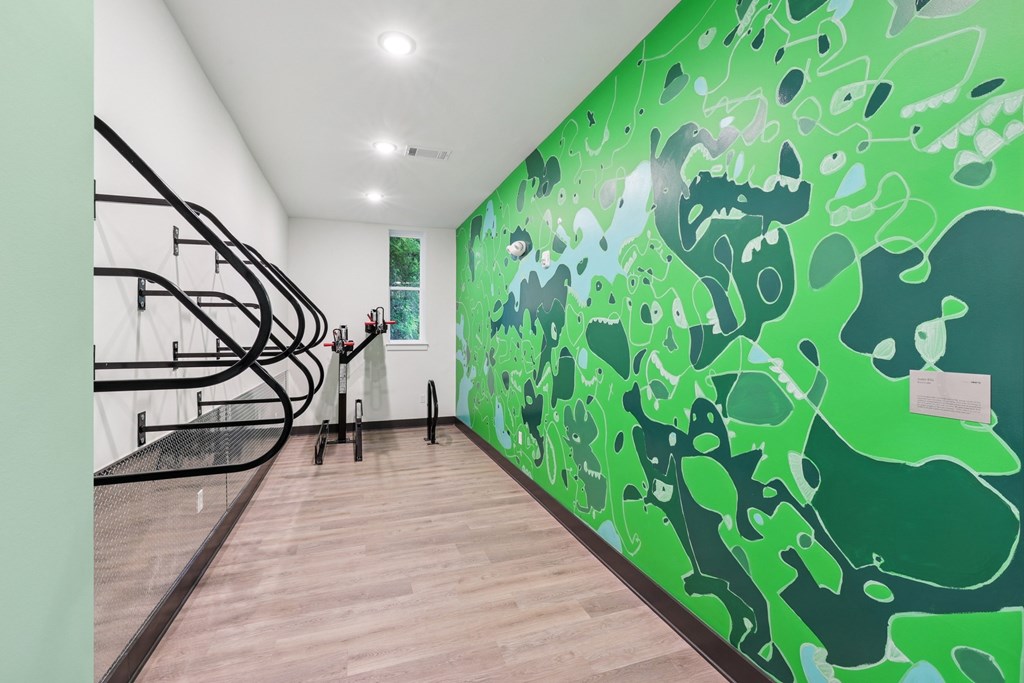 A staircase with a green wall with a painting on it at Link Apartments® CYKEL Apartments, Charlotte, NC, 28208