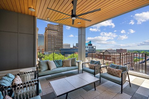 a balcony with a view of the city and a couch and a table at Link Apartments® 4th Street, North Carolina, 27101