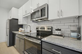 a modern kitchen with stainless steel appliances and granite counter tops at Link Apartments® Calyx, Chapel Hill North Carolina